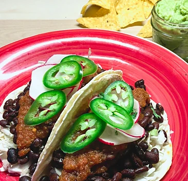 Rancheros tacos with black beans and sliced jalapeño