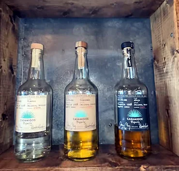 Tequila bottles on a wooden bar shelf