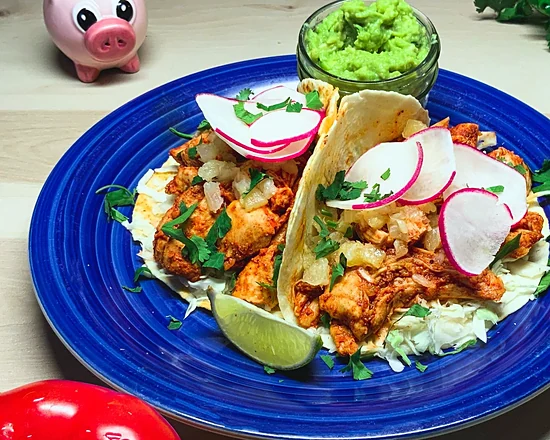 Chicken al pastor tacos with pineapple, radish and cilantro on a blue plate