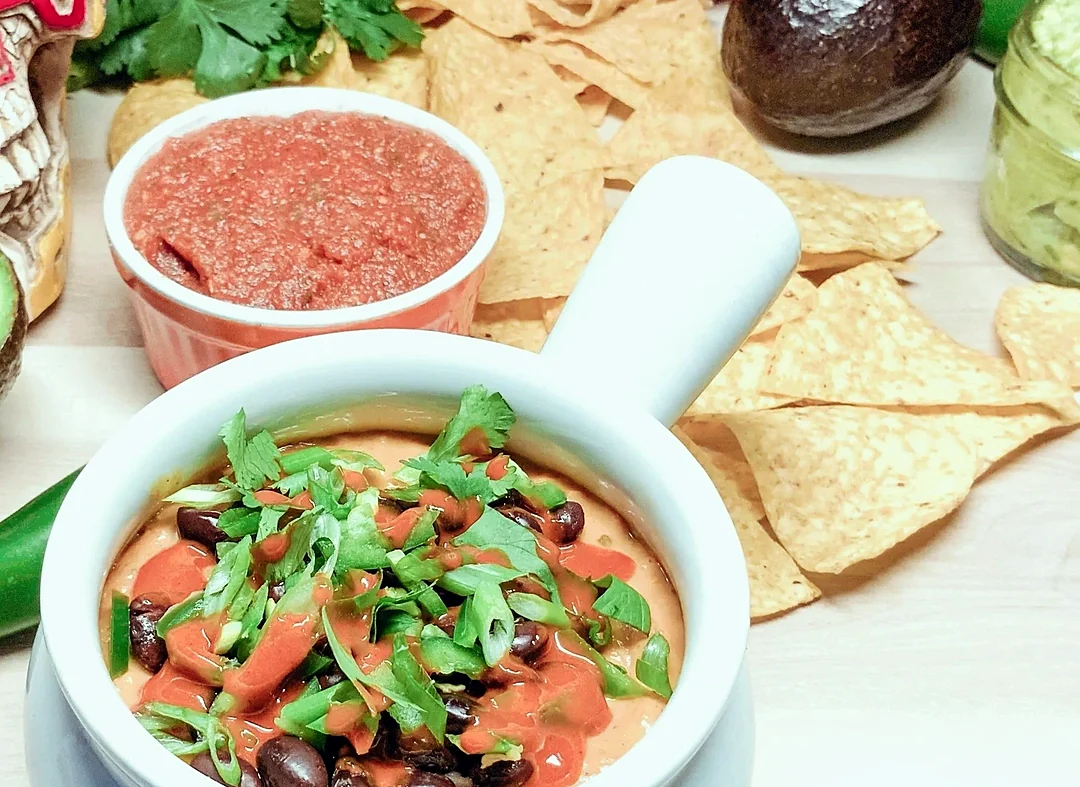 Queso fundido with black beans and green onion, with salsa and tortilla chips